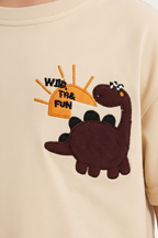 Enfant en ensemble dinosaure beige et bleu - détail appliqué dinosaure marron orange - BabyCoton