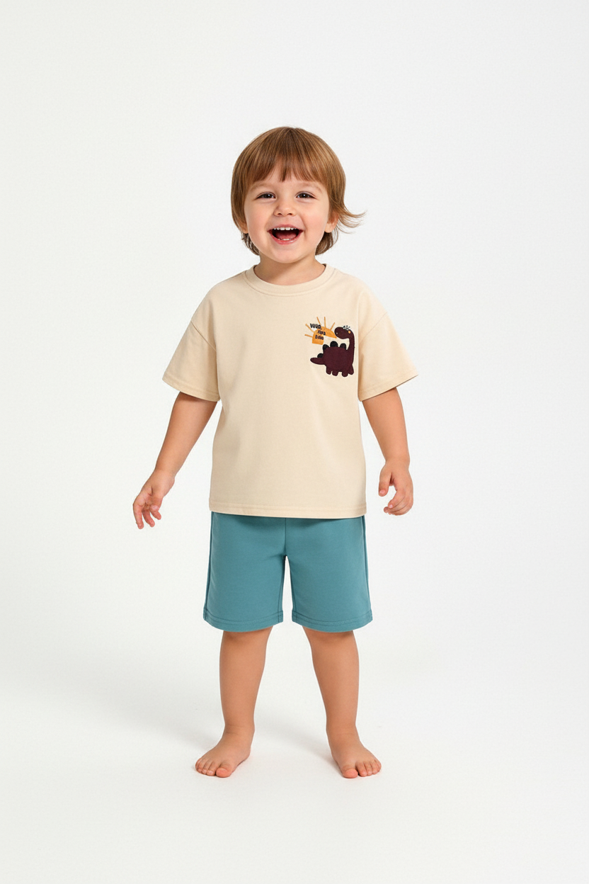 Enfant en ensemble dinosaure beige et bleu - t-shirt beige appliqué dinosaure et short turquoise - vue de face - BabyCoton