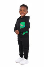Enfant portant ensemble hoodie Dinosaure graphique et pantalon - vue trois-quarts - détail design préhistorique dynamique - photo produit fond blanc - BabyCoton Suisse
