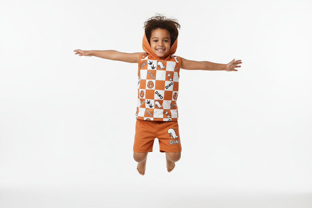 Enfant sautant en l'air avec joie en portant un débardeur à capuche orange à carreaux avec motifs dinosaures DINO et short orange assorti
