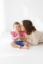 Ensemble bébé fille papillon — top blanc manches volantées rose et short jean bleu, moment câlin maman et bébé fond blanc