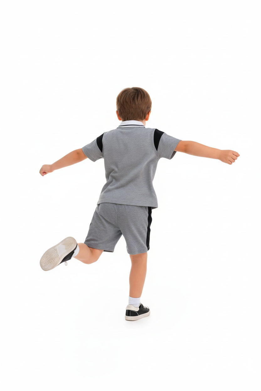 "Enfant 5-6 ans en pleine action vue de dos arrière - Ensemble polo et short sportif gris chiné - Vue arrière complète montrant polo avec col blanc bordé noir, manches courtes avec bandes noires latérales - Short gris avec bandes noires contrastantes sur les côtés, logo Y visible - Coupe athlétique confortable en mouvement - Liberté de mouvement totale pour jouer et courir - Fond blanc professionnel studio - Photo lifestyle e-commerce dos BabyCoton Suisse - Tenue sportive casual garçon"

