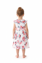 Fille en robe blanche plissée fleurie roses - vue de dos montrant col volant et jupe plissée évasée - BabyCoton
