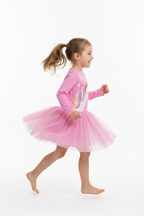Fillette courant joyeusement en portant la robe tulle licorne rose - vue de profil - fond blanc studio