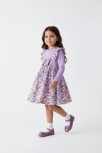 Fillette en robe violette à fleurs - pose en marche