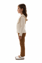 Fillette portant ensemble haut côtelé à volants et pantalon velours côtelé - vue de profil latérale - silhouette élégante texturée - fond blanc studio - BabyCoton Suisse
