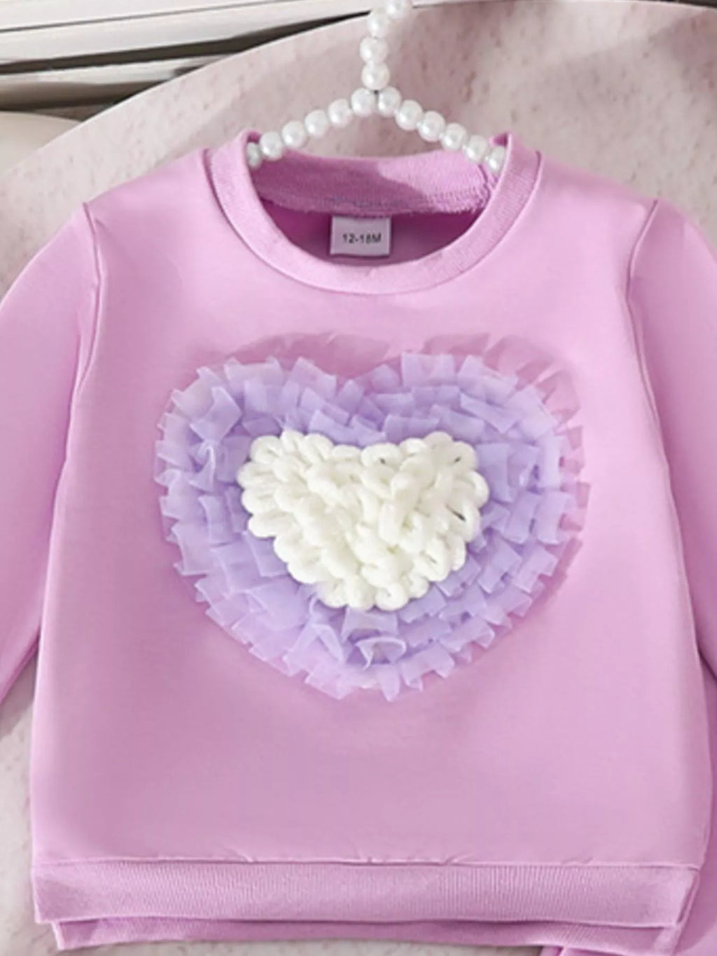 Gros plan motif cœur sur haut col rond enfant - design adorable et délicat - vêtements BabyCoton

