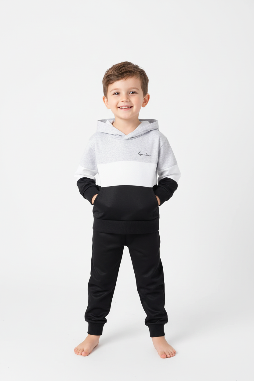 Enfant debout portant ensemble hoodie color block et pantalon noir - vue de face complète sur fond blanc studio