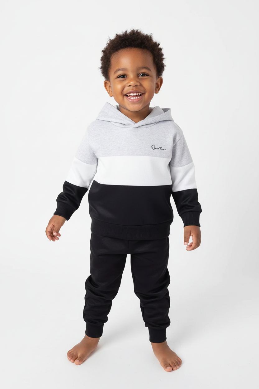 Enfant souriant face caméra avec ensemble hoodie casual blanc et noir - portrait studio chaleureux