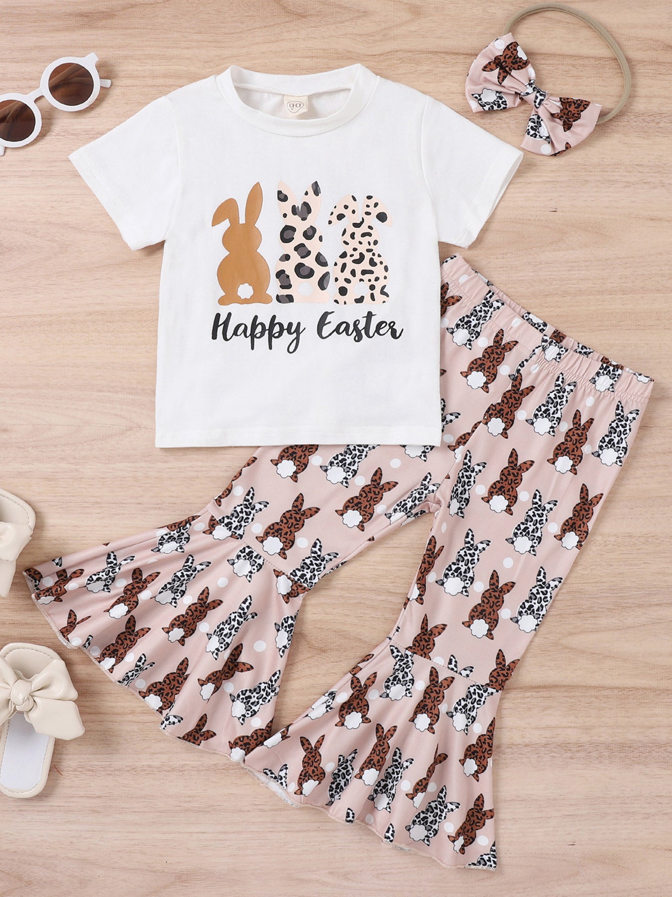 Détail gros plan imprimé lapins léopard t-shirt Happy Easter et tissu pantalon évasé rose — ensemble fillette BabyCoton, fond blanc