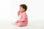 Vue de profil d'un bébé portant un sweat rose col rond avec appliqué cœur en relief rose et blanc et pantalon rose assorti
